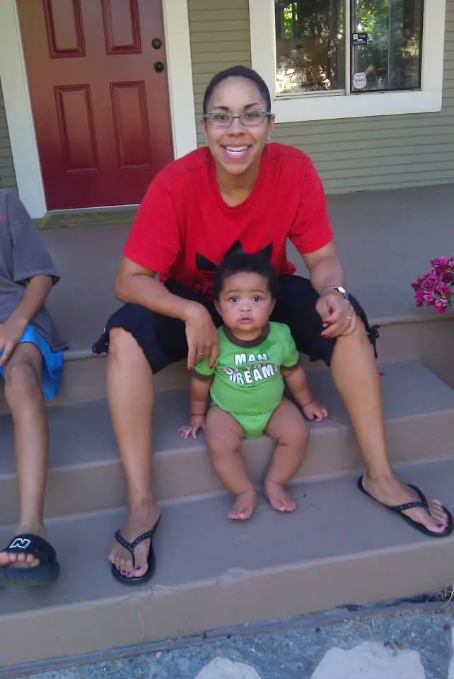 Lisa smiling with Landon as a young child while sitting on the front steps